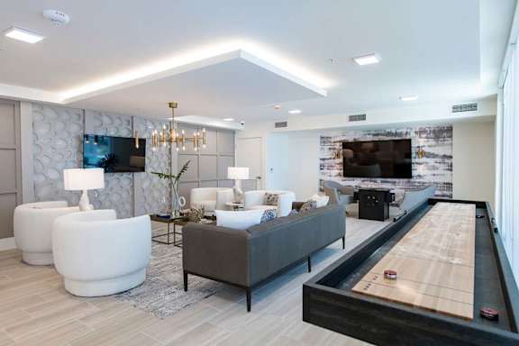 A modern living room with a pool table and a television.