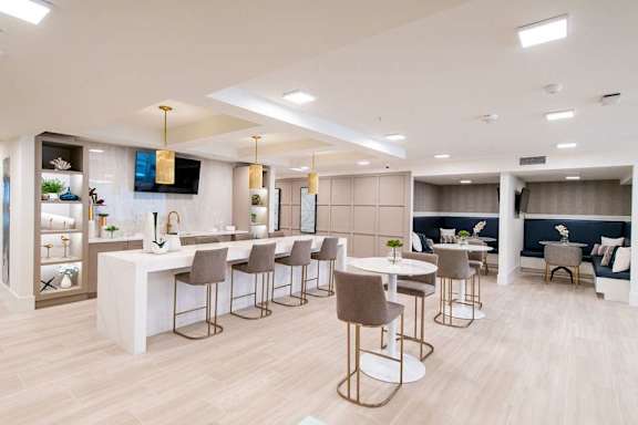 A modern dining area with a bar and chairs.