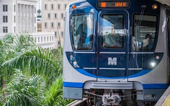 a blue and white train traveling down train tracks