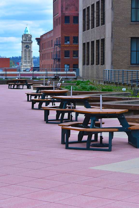 Picnic tables are lined up on a pink patio at 7 West 7th Apartments, Cincinnati, 45202