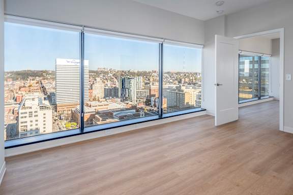 A room with a view of a cityscape through large windows at 7 West 7th Apartments, Cincinnati Ohio