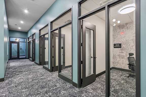 A hallway with glass doors and a carpeted floor. at LiveWell Apartments, Pennsylvania, 15222