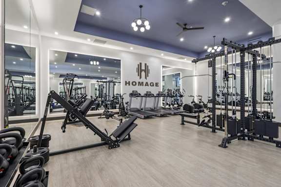 A gym with a variety of equipment including weights and cardio machines at LiveWell Apartments, Pennsylvania