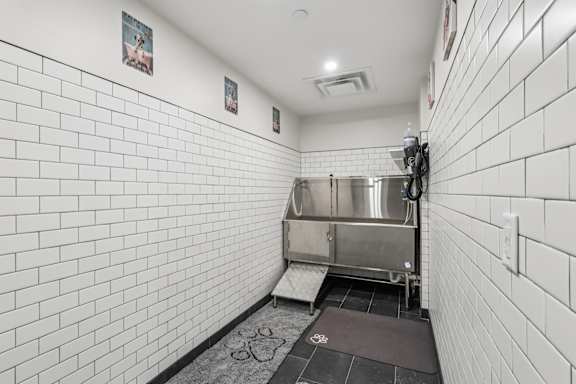 A white tiled bathroom with a sink and a toilet. at LiveWell Apartments, Pittsburgh 15222
