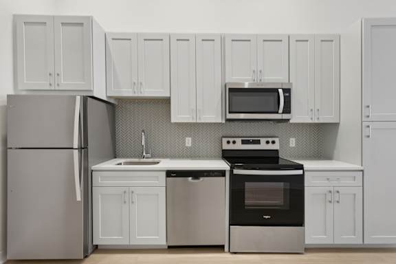 A kitchen with white cabinets and appliances. at LiveWell Apartments, Pennsylvania