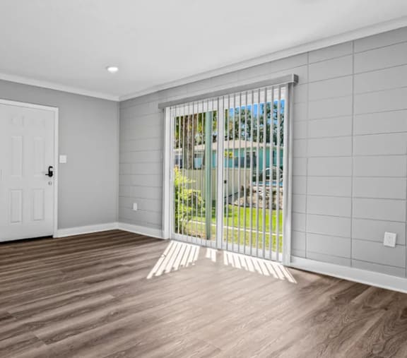 A room with a sliding door leading to a backyard.