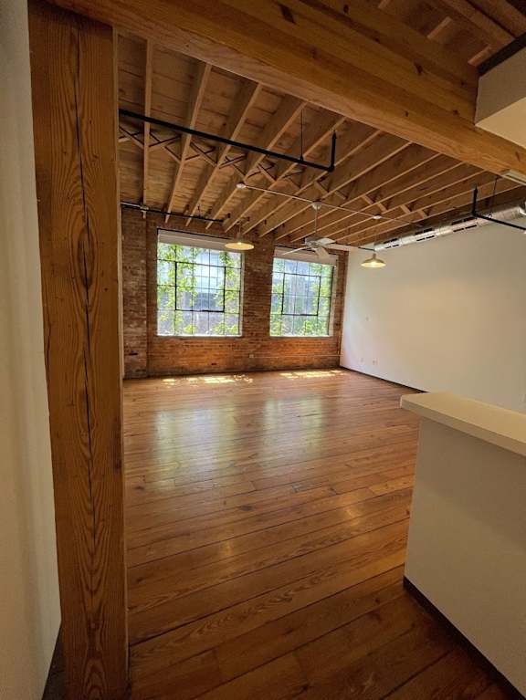 an empty room with wooden floors and exposed ceilings