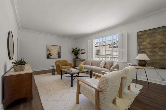 A living room with a white sofa and a wooden table.