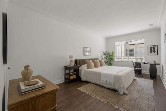 A bedroom with a large bed and a wooden coffee table.