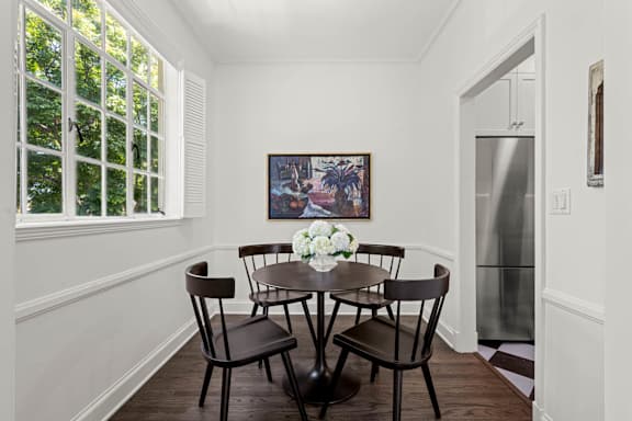 A dining room with a table set for four.