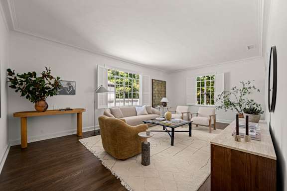A living room with large windows with a view of trees.