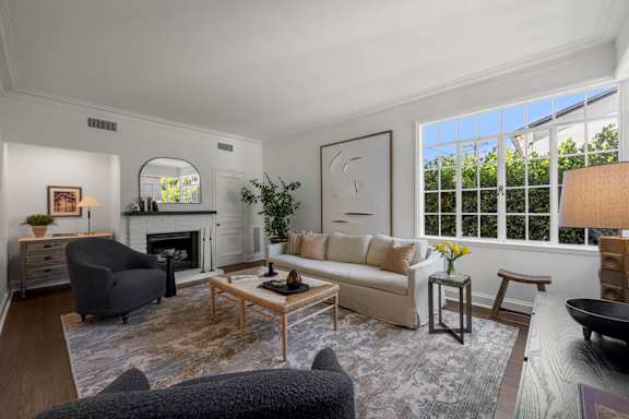 A living room with a fireplace and large windows.