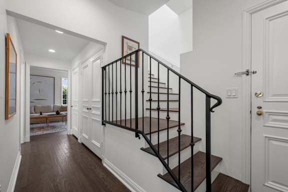 A staircase with a black railing and wooden steps.