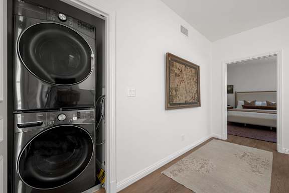 A laundry room with a washer and dryer and a rug on the floor.
