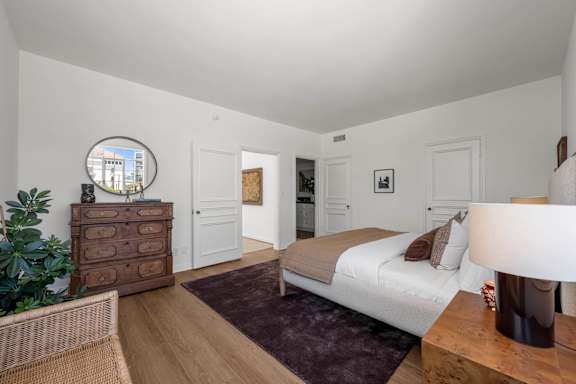 A bedroom with a bed, dresser, and mirror.