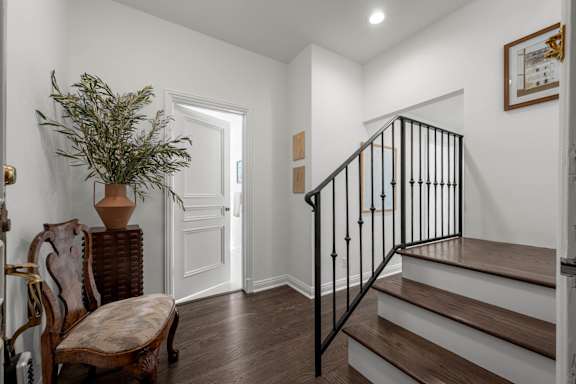 A staircase with a wooden handrail and steps leading up to a doorway.
