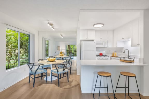 a kitchen with a breakfast bar and a table with stools