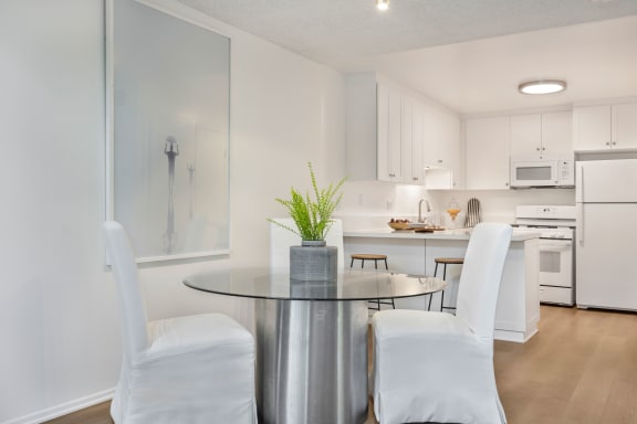 a dining room with white chairs and a table