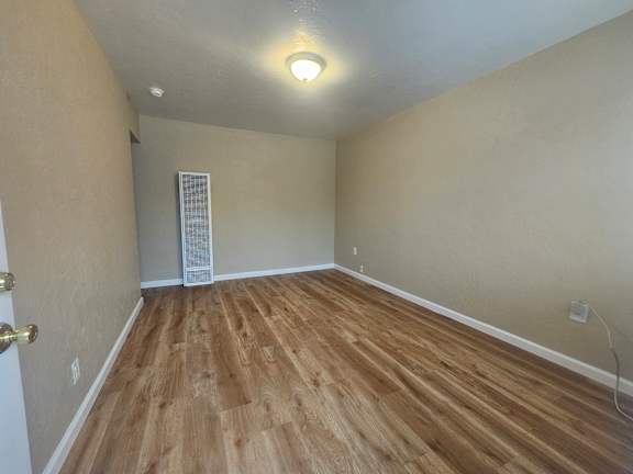A room with wooden flooring and a white ceiling.