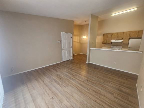 A room with wooden flooring and a white door.