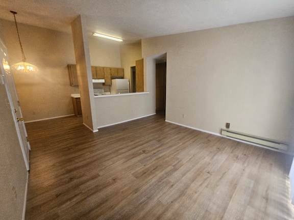 A room with wooden flooring and a mirror on the wall.