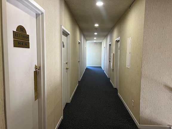 A hallway with a sign that says restroom men.