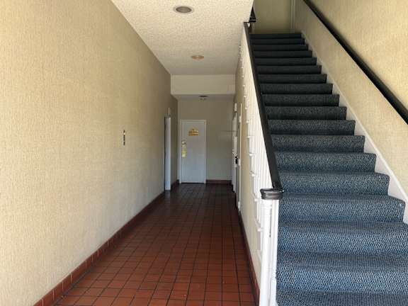 A hallway with a staircase on the right side.
