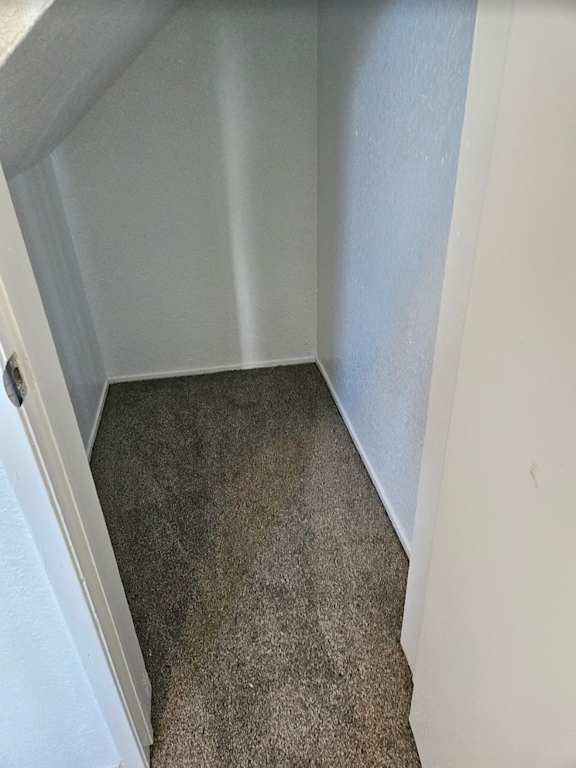 a room with a carpeted floor and a white wall
