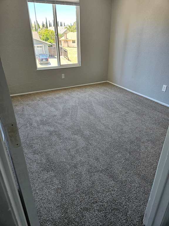 a carpeted living room with a large window