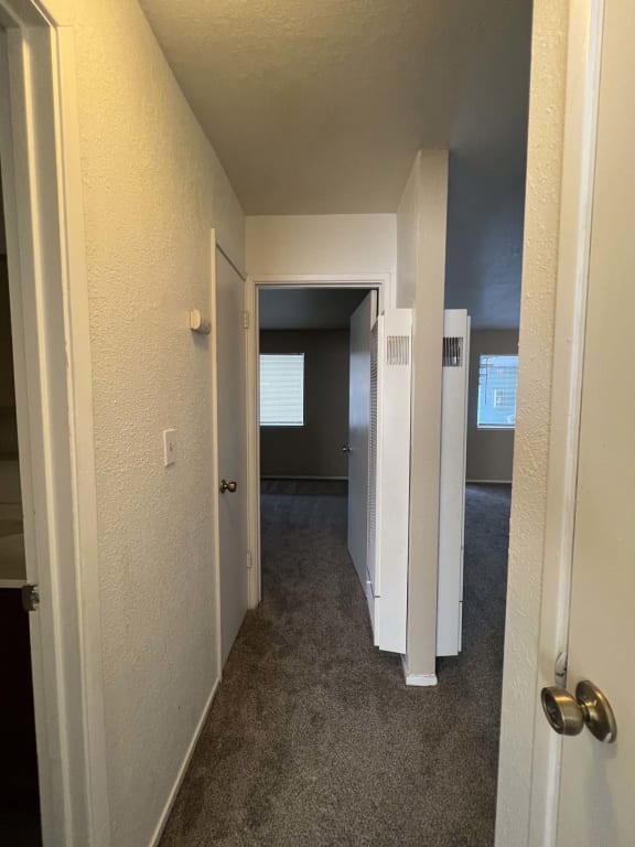 a hallway with a door open to a room with an open door