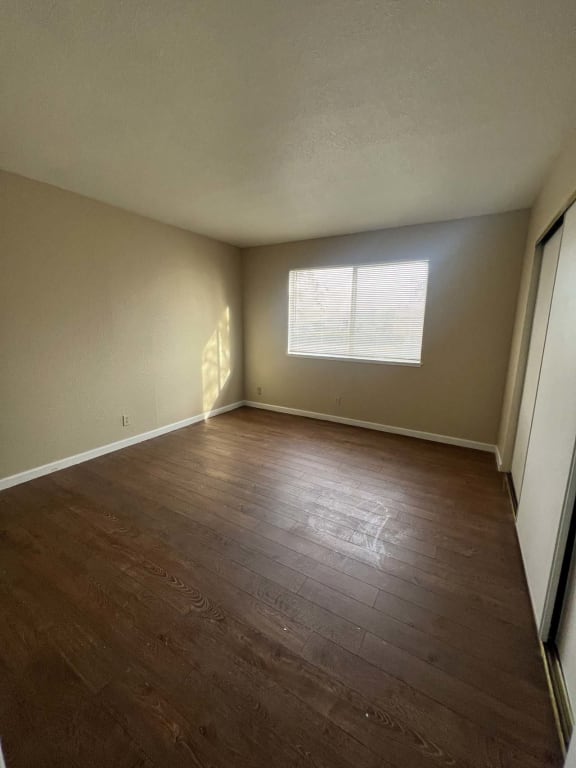 a empty room with wooden floors and a window