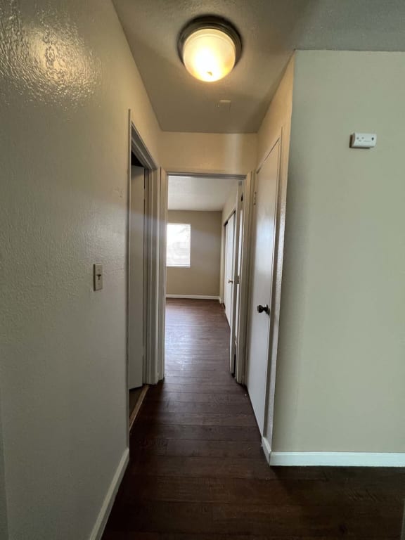 a hallway with white walls and a ceiling with a light