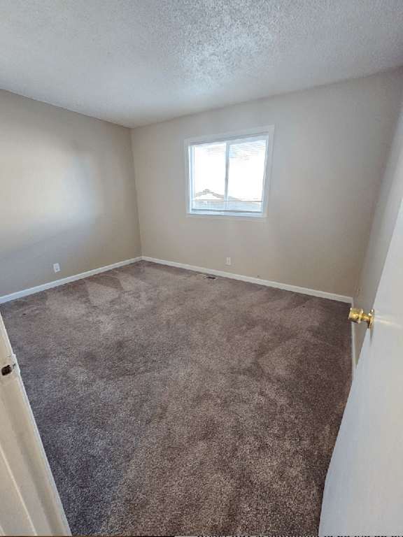 an empty room with carpet and a window