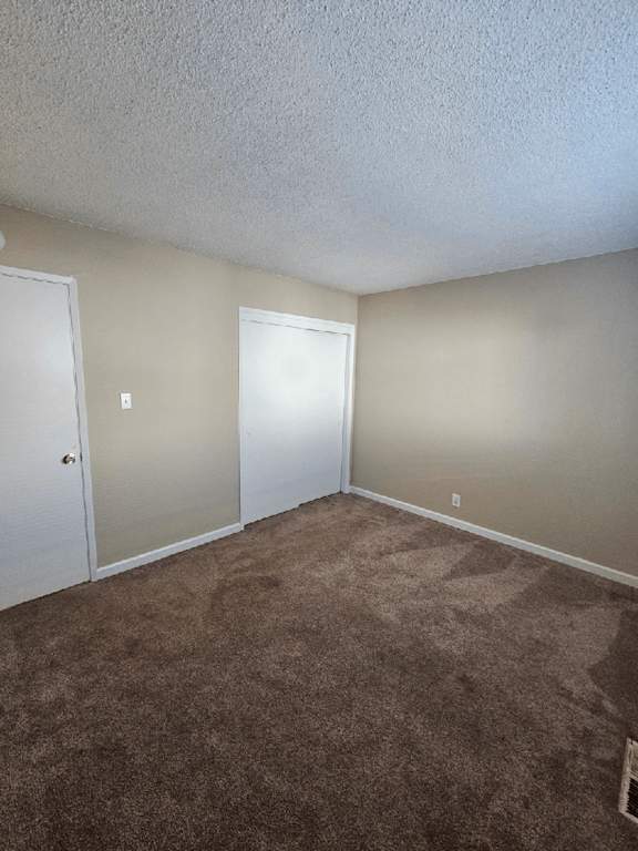 an empty living room with carpet and a door