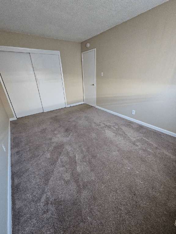 an empty room with a carpeted floor and white walls