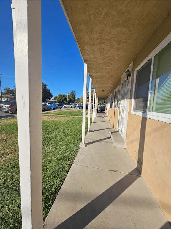 a view of the outside of a building with a sidewalk