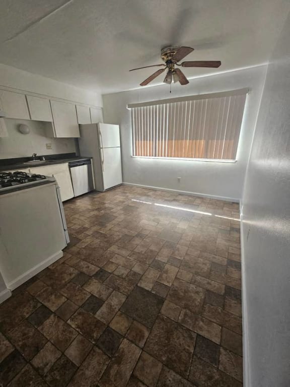 an empty kitchen with a ceiling fan