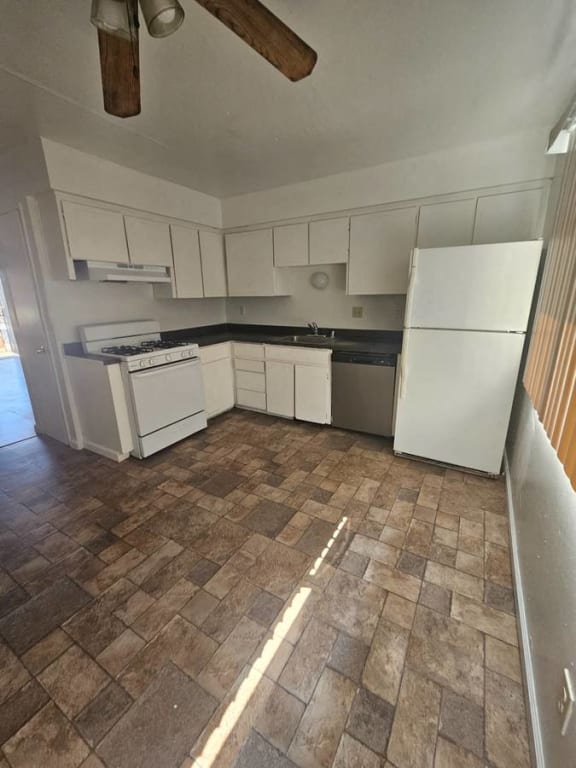 an empty kitchen with white appliances and white cabinets