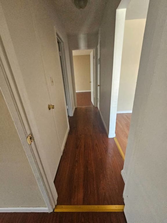 a hallway with a hard wood floor and white walls