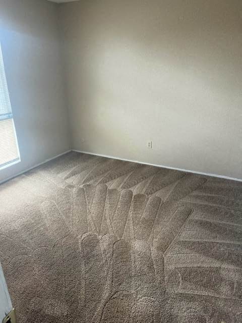 an empty room with a carpeted floor and a window