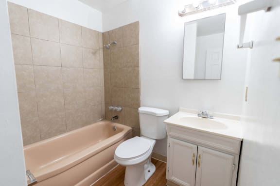 a bathroom with a toilet and a tub and a sink