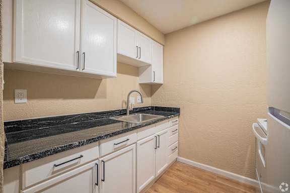 Floor Plan  A kitchen with white cabinets and a black countertop.