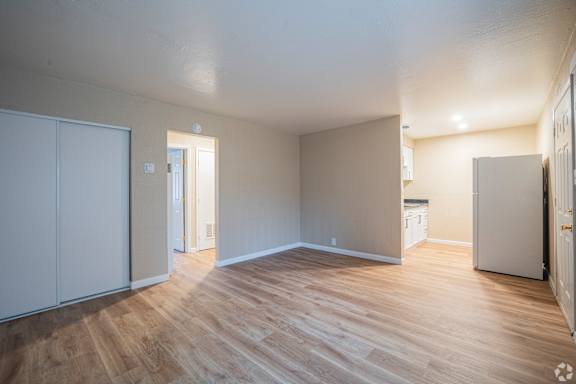 A room with wooden flooring and white walls.
