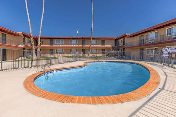A swimming pool in a courtyard surrounded by a fence.