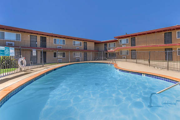 A swimming pool in front of apartment buildings.