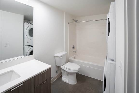 A white toilet sits next to a white sink in a small bathroom.