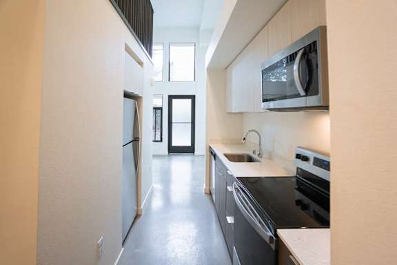 A modern kitchen with black appliances and white countertops.