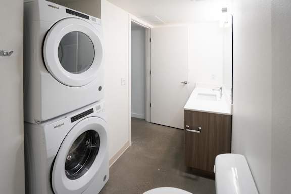 A white washing machine and dryer in a small laundry room.