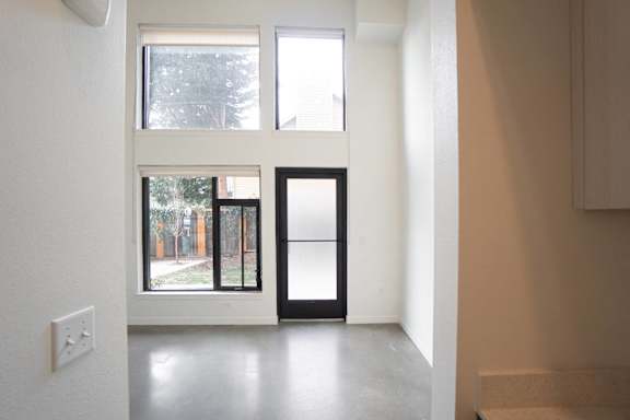 A white room with a window and a door.