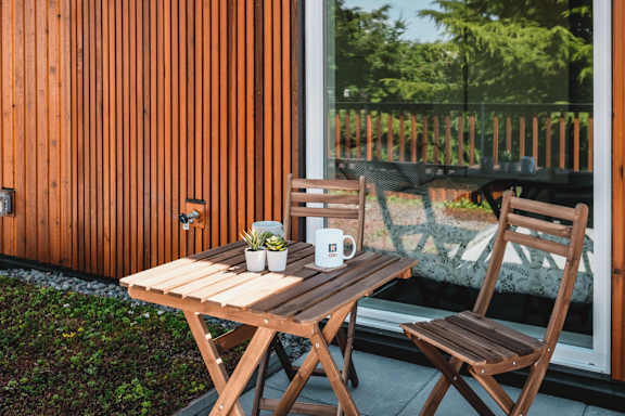 a table and chairs on a patio next to a window
